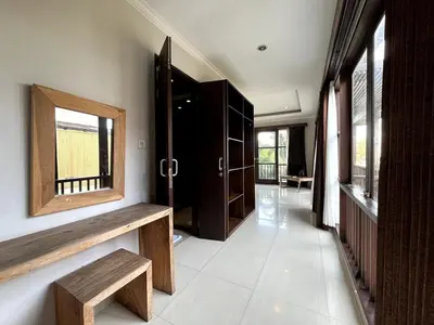 a hallway with a mirror and a bench and windows at White Lotus Villa by Miel Property in Seminyak