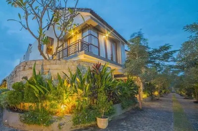 a house with lights on the side of it at Grand Kesambi Family Villa by Miel Property in Seminyak