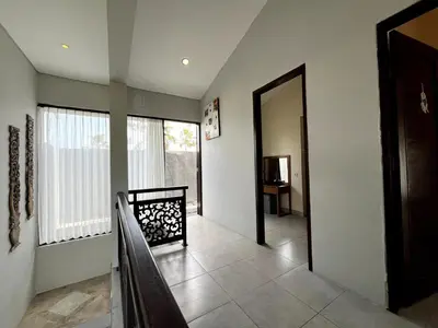 a hallway with a door to a room with a window at Grand Kesambi Family Villa by Miel Property in Seminyak