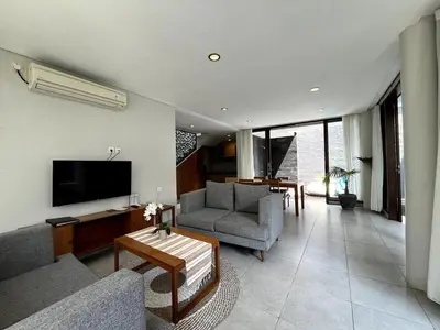a living room with a couch and a tv at Grand Kesambi Family Villa by Miel Property in Seminyak