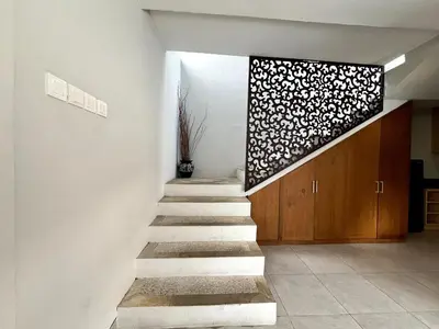 a staircase in a house with a flower wall at Grand Kesambi Family Villa by Miel Property in Seminyak