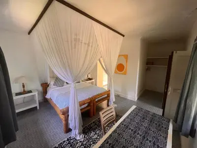 a bedroom with a canopy bed with white curtains at Large Private Villa, central Seminyak, Bali in Seminyak