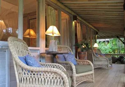 a porch with wicker chairs and a table with a lamp at Large Private Villa, central Seminyak, Bali in Seminyak