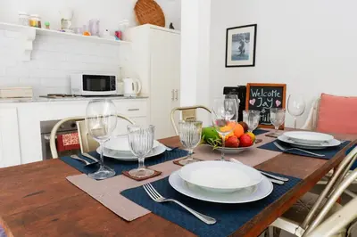 a dining room table with plates and wine glasses at VILLA BELLA - 7Min Beach Access - 10min to Canggu in Canggu