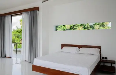 a white bedroom with a bed and a window at Villa Manis with a private pool in Nusa Dua in Nusa Dua