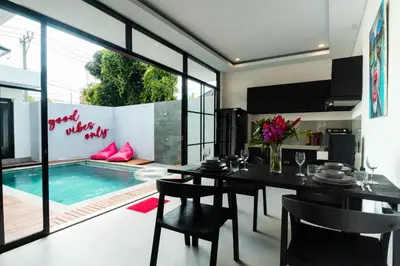 a dining room with a table and a swimming pool at Stylish Umalas 2BR Villa With Private Pool in Kerobokan