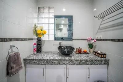 a bathroom with a sink and a vase with flowers at KUTA - 3 Bedroom Private Pool Villa on Jl Mataram! in Kuta