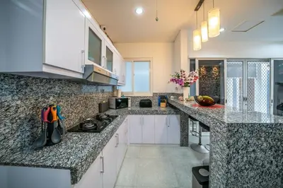 a kitchen with white cabinets and granite counter tops at KUTA - 3 Bedroom Private Pool Villa on Jl Mataram! in Kuta