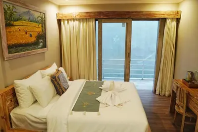a bedroom with a bed and a large window at Koura Jimbaran in Badung