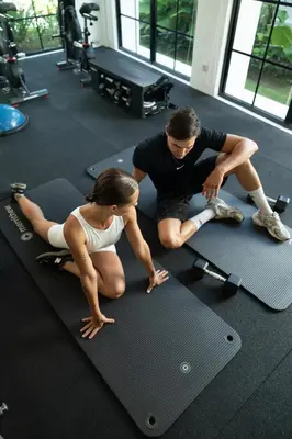 a man and a woman sitting on a gym mat at Kiara Ocean Place in Canggu