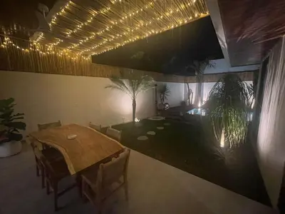a dining room with a table and some plants at Cozy 3 Bedrooms Villa Umalas in Kerobokan
