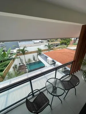 a balcony with a table and chairs and a swimming pool at Cozy 3 Bedrooms Villa Umalas in Kerobokan