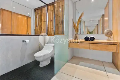 a bathroom with a toilet and a sink and a mirror at Bamila Villa by Kozystay - Umalas in Canggu