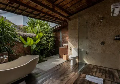 a bathroom with a bath tub and a toilet at Natajiwa Village close to Canggu and Seminyak in Seminyak