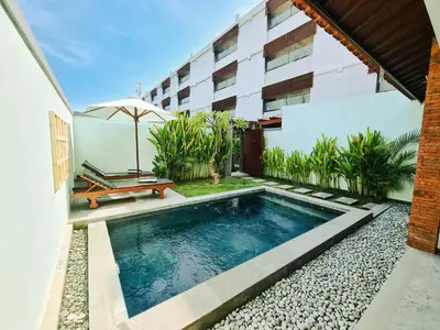a swimming pool in front of a building at Sejati Villas - Petitenget in Seminyak