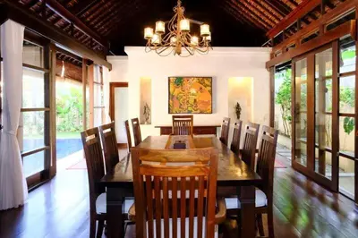 a dining room with a table and chairs and a chandelier at Villa Jepun Seminyak in Canggu