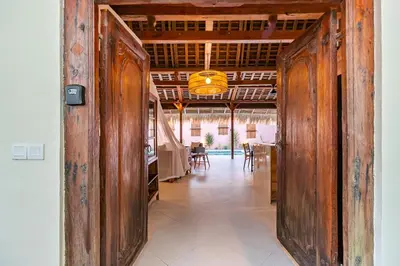 a hallway with wooden doors in a house at Villa Madah - Secluded & Romantic Retreat 1BR Near Umalas with Private Pool & View in Kerobokan