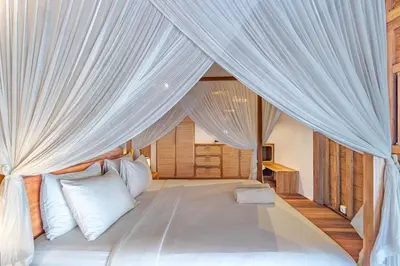 a bedroom with a canopy bed with white curtains at Villa Madah - Secluded & Romantic Retreat 1BR Near Umalas with Private Pool & View in Kerobokan