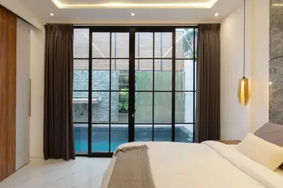 a bedroom with a bed and a large window at Cozy Seminyak Loft 360 Sweet in Seminyak