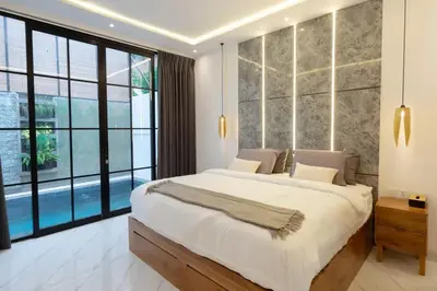 a bedroom with a large bed and large windows at Cozy Seminyak Loft 360 Sweet in Seminyak