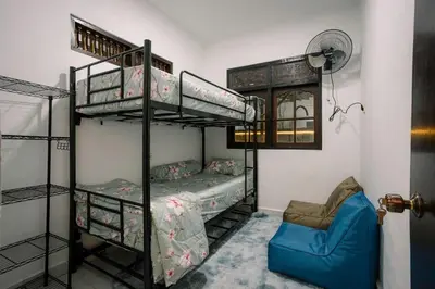 a bedroom with two bunk beds and a blue couch at Hawaiian Beach House in Legian