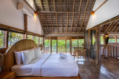 a bedroom with a bed in a room with windows at Villa Vintage 3 in Canggu