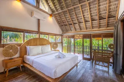a bedroom with a bed in a room with windows at Villa Vintage 3 in Canggu