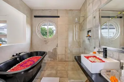 a bathroom with a black tub and a sink at Villa Roma in Seminyak