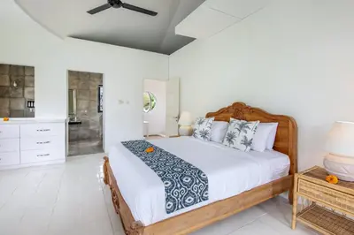 a bedroom with a large bed and a bathroom at Villa Roma in Seminyak