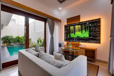 a living room with a white couch and a tv at Villa Boswellia Seminyak near Double Six Beach in Seminyak