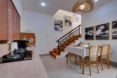 a kitchen with a table and chairs and a stove at Villa Boswellia Seminyak near Double Six Beach in Seminyak