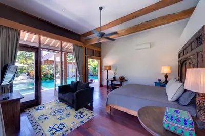 a bedroom with a bed and a chair and a table at Kudus Boutique Estate in Canggu 100m to Beach in Canggu