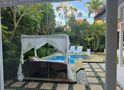 a bedroom with a canopy bed next to a pool at White Sands Private Villa in Seminyak