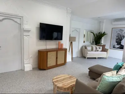 a living room with a couch and a tv on a wall at White Sands Private Villa in Seminyak