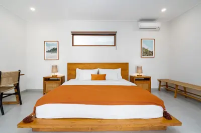 a bedroom with a large bed and two tables at Beta Stay and Surf in Canggu