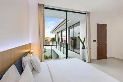 a bedroom with a bed and a large window at New 3 BR Luxury Villa in Umalas in Canggu