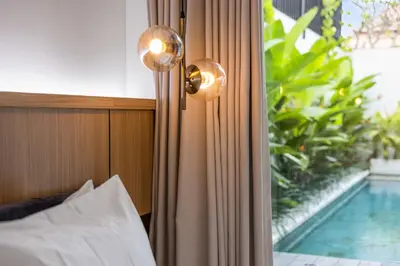 a bedroom with a bed and a window with a swimming pool at New 3 BR Luxury Villa in Umalas in Canggu