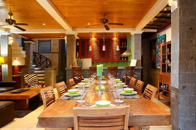 a dining room with a long wooden table and chairs at Villa SanSam Seminyak in Seminyak