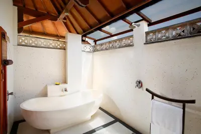 a white bath tub in a bathroom with a window at Villa SanSam Seminyak in Seminyak