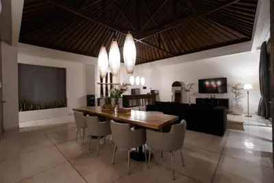 a dining room with a wooden table and chairs at Villa Duadewi 3BR in the Heart of Seminyak by Santi Management in Seminyak