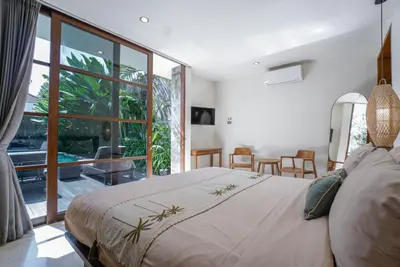 a bedroom with a large bed and a large window at Villa Duadewi 3BR in the Heart of Seminyak by Santi Management in Seminyak