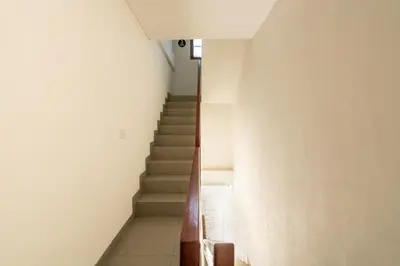 a staircase in a building with white walls and a stair case at Adikara Apartment by Betterplace in Canggu