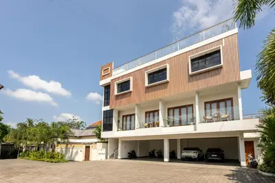 a building with two cars parked in front of it at Adikara Apartment by Betterplace in Canggu