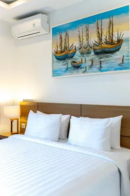 a bedroom with a bed with two boats in the water at Adikara Apartment by Betterplace in Canggu