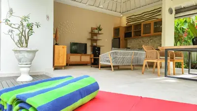 a living room with a couch and a tv at Seminyak Square Hotel And Villas in Seminyak