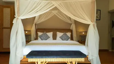 a bedroom with a canopy bed with a blue rug at Seminyak Square Hotel And Villas in Seminyak