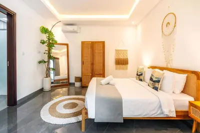 a bedroom with a large bed and a couch at Villa Taj - Luxury 3-bedroom Pool Villa Near Seminyak in Kerobokan