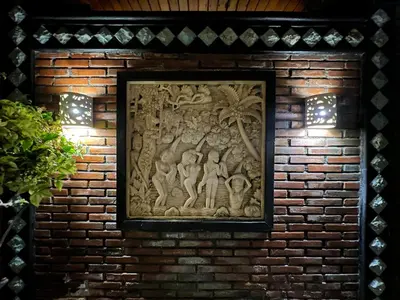 a stone relief on a brick wall with lights at Villa Mutti in Seminyak