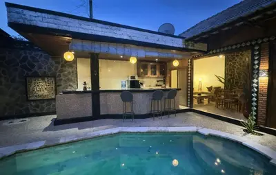 a backyard with a swimming pool and a kitchen at Villa Mutti in Seminyak