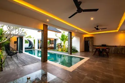 a swimming pool in a villa with a dining area at Villa Yolanda - Seminyak Beach in Seminyak